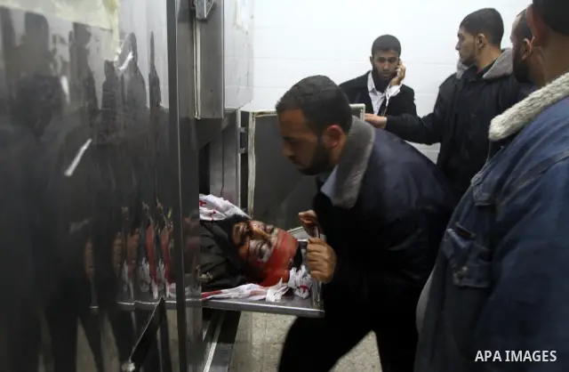 Members of Hamas' security forces stand next to the body of a militant after an Israeli air strike in Deir Al-Balah in the central Gaza Strip April 2, 2011. Israeli aircraft killed three Palestinian gunmen in the souther...