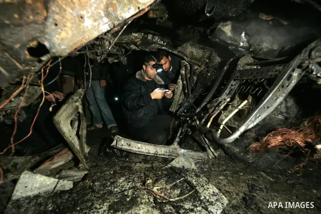 Palestinian Hamas officers inspect a vehicle following an Israeli airstrike that killed three of Hamas militants near Deir Al Balah, central Gaza Strip, early Saturday, April 2, 2011. Israeli aircraft killed the militant...