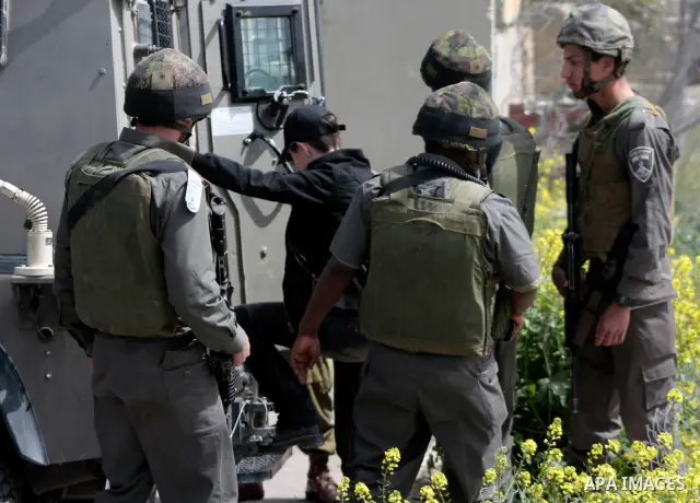 Israeli soldiers detain a demonstrator during a protest by foreign, Israeli and Palestinian demonstrators against the controversial Israeli separation barrier, in the Palestinian village of Beit Omar, near the West Bank...