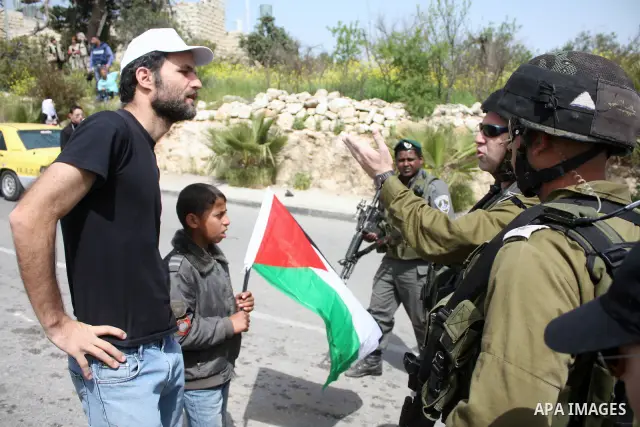 A Palestinian boy argues with Israeli soldiers during a protest by foreign, Israeli and Palestinian demonstrators against the controversial Israeli separation barrier, in the Palestinian village of Beit Omar, near the We...