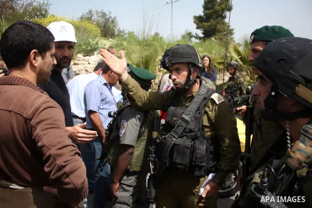 A Palestinian boy argues with Israeli soldiers during a protest by foreign, Israeli and Palestinian demonstrators against the controversial Israeli separation barrier, in the Palestinian village of Beit Omar, near the We...