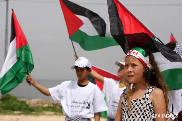 Palestinian children hold up national flags during a rally against the settlements and Israel's separation barrier in the West Bank village of Nabi Salah, near Ramallah on April 2,2011. Photo by Issam Rimawi