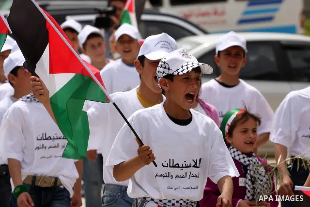 Palestinian children hold up national flags during a rally against the settlements and Israel's separation barrier in the West Bank village of Nabi Salah, near Ramallah on April 2,2011. Photo by Issam Rimawi