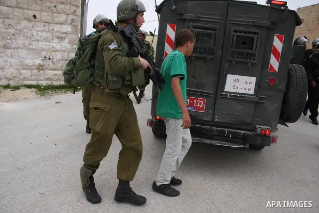 Israeli soldiers detain a Palestinian youth who they said was throwing stones during a demonstration against the expansion of the nearby Jewish settlement of Halamish in the West Bank village of Nabi Saleh near Ramallah,...