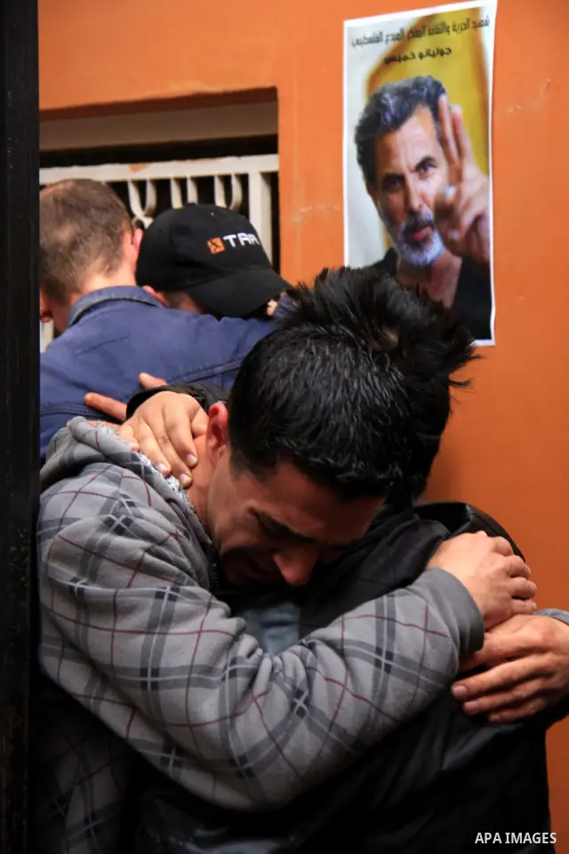 Palestinians mourn next to posters depicting Arab-Israeli actor and director Juliano Mer Khamis during a rally outside the Freedom Theatre, owned by Mer Khamis, in Jenin refugee camp, near the West Bank city of Jenin Apr...