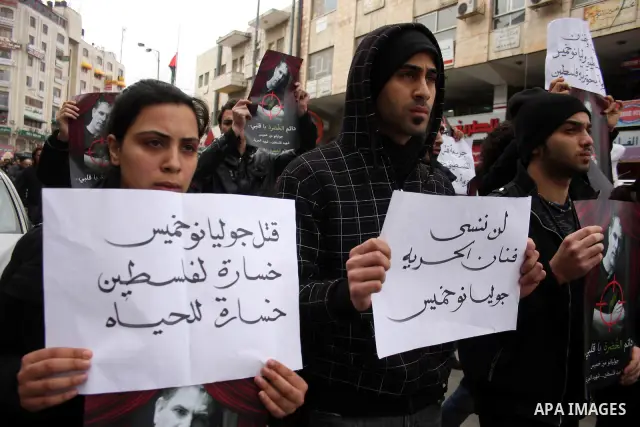 Palestinians hold signs and posters depicting Arab-Israeli actor and director Juliano Mer Khamis during a rally in the West Bank city of Ramallah on April 5, 2011. A senior Palestinian security official said on Tuesday p...