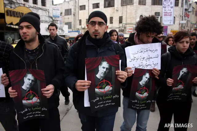 Palestinians hold signs and posters depicting Arab-Israeli actor and director Juliano Mer Khamis during a rally in the West Bank city of Ramallah on April 5, 2011. A senior Palestinian security official said on Tuesday p...