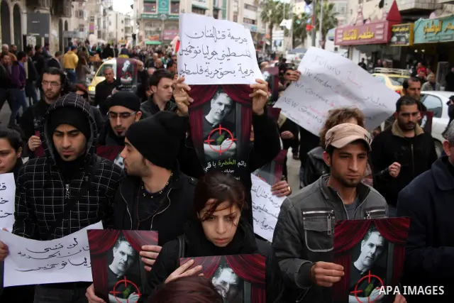 Palestinians hold signs and posters depicting Arab-Israeli actor and director Juliano Mer Khamis during a rally in the West Bank city of Ramallah on April 5, 2011. A senior Palestinian security official said on Tuesday p...