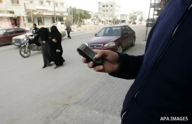 Palestinian man looks at his mobile phone after he received SMS message from the Israeli intelligence in Rafah, southern Gaza Strip on April 05,2011. Israeli intelligence services use SMS messages to search for the soldi...