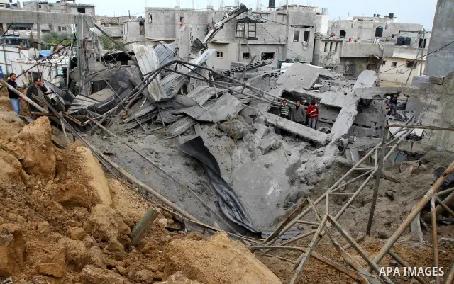 Palestinians inspect a destroyed plastics factory in Gaza City on April 6, 2011, after Israeli aircraft attacked two targets in the Gaza Strip wounding four people, among them a pregnant woman, Palestinian medics and wit...