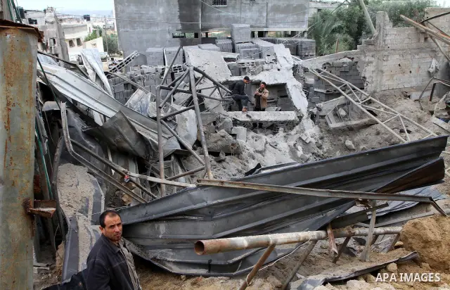 Palestinians inspect a destroyed plastics factory in Gaza City on April 6, 2011, after Israeli aircraft attacked two targets in the Gaza Strip wounding four people, among them a pregnant woman, Palestinian medics and wit...