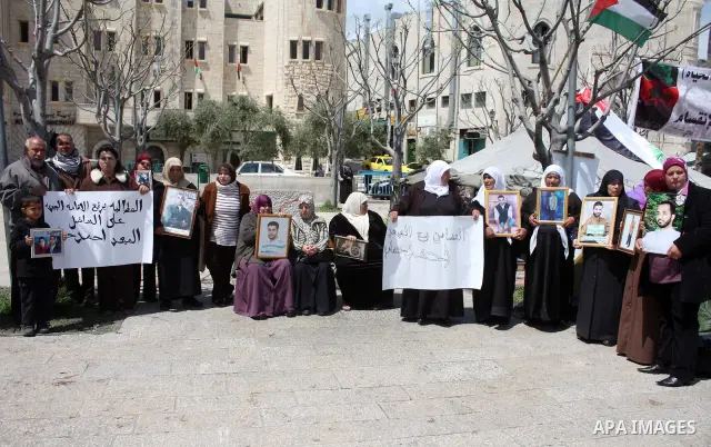 Palestinian women hold pictures of jailed relatives during a protest in the West Bank city of Bethlehem calling for their release from Israeli prisons on April 06, 2011. Photo by Najeh Hashlamoun