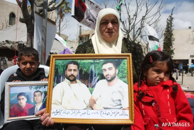 Palestinian women hold pictures of jailed relatives during a protest in the West Bank city of Bethlehem calling for their release from Israeli prisons on April 06, 2011. Photo by Najeh Hashlamoun