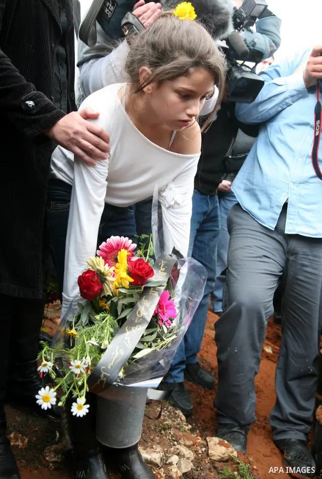 Milay, daughter of Arab-Israeli actor and director Juliano Mer Khamis, holds a flower as she stands next to her father's coffin during the funeral procession in Haifa, northern Israel, Wednesday, April 6, 2011. Mer-Khami...