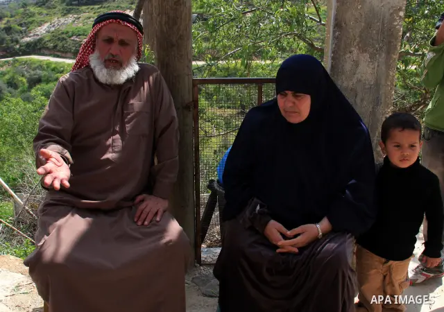 Palestinian Asad Lolah and his wife Rehab Lolah sit at the family house's yard after their release from an Israeli army overnight detention, in the West Bank village of Awarta near Nablus, Thursday, April 7, 2011. Palest...