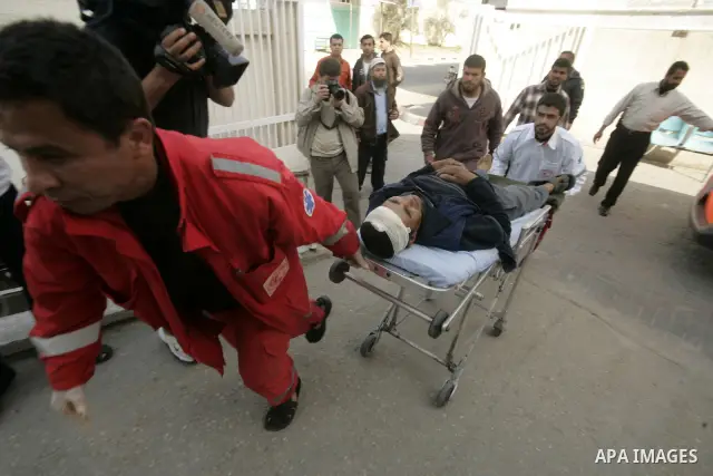 A wounded Palestinian man is wheeled by medics at the al_Najar hospital in the southern Gaza Strip, Wednesday, April 7, 2011, after his house was hit by Israeli shell fired towards Gaza Strip near the border between sout...