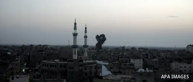 Smoke billows behind buildings from smuggling tunnels linking the southern Gaza Strip to Egypt targeted by an Israeli raid in the town of Rafah on April 7, 2011 killing two people and wounding 14. The shelling came short...