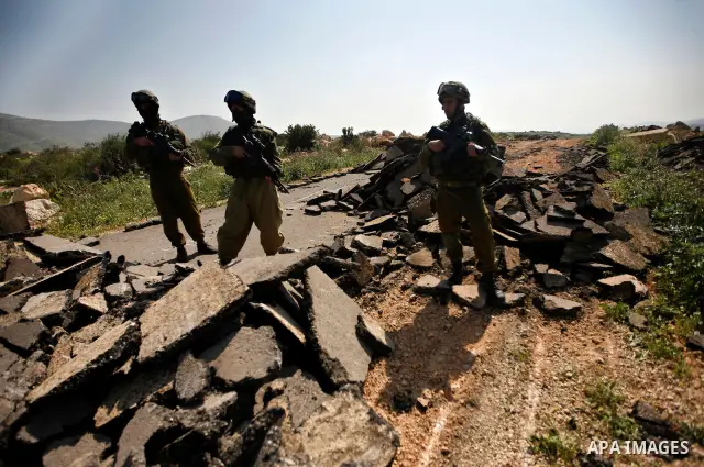 An Israeli earth-mover destroys a main road in Aqaba near the West Bank village of Tubas in the northern Jenin region on April 7, 2011 as the military used bulldozers to destroy Palestinian houses in another farming vill...