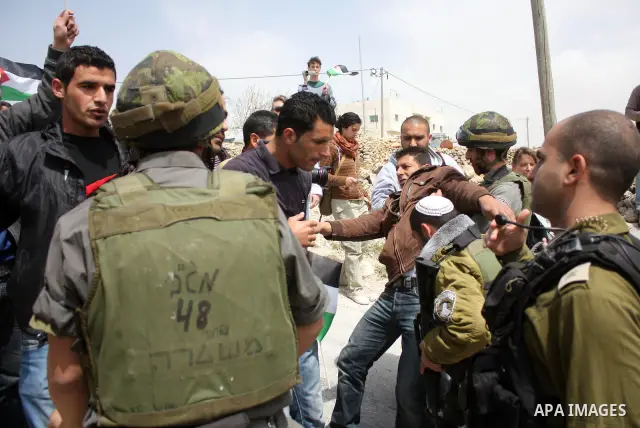 Protesters argue with an Israeli soldier during a demonstration against Israel's controversial separation barrier in the West Bank village of Maasarah, near the biblical town of Bethlehem on April 08, 2011.Israel says th...
