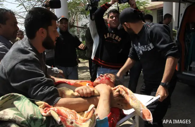 The body of 21-year-old Nidal Qudeih is carried into the mortuary of a hospital in the southern Gaza Strip city of Khan Yunis following an Israeli air strike on the Qarara region, northeast of Khan Yunis, on April 8, 201...