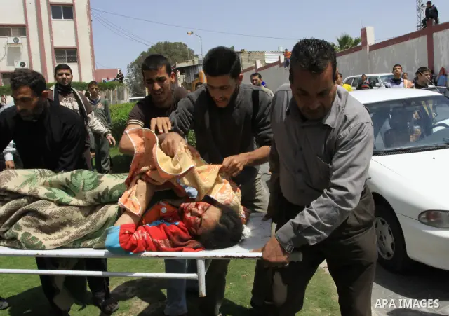The body of 21-year-old Nidal Qudeih is carried into the mortuary of a hospital in the southern Gaza Strip city of Khan Yunis following an Israeli air strike on the Qarara region, northeast of Khan Yunis, on April 8, 201...