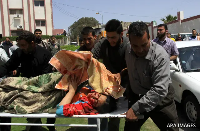 The body of 21-year-old Nidal Qudeih is carried into the mortuary of a hospital in the southern Gaza Strip city of Khan Yunis following an Israeli air strike on the Qarara region, northeast of Khan Yunis, on April 8, 201...