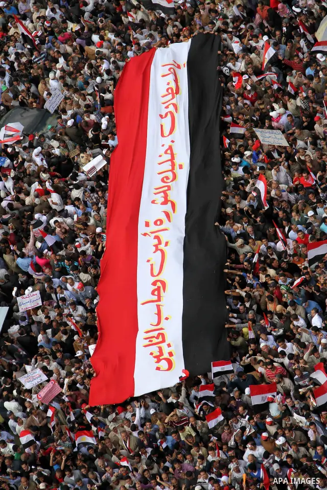 Egyptians hold giant flag as tens of thousands gathered for a demonstration at Cairo's Tahrir Square on April 8, 2011, two months after president Hosni Mubarak was ousted, to demand that former regime officials including...