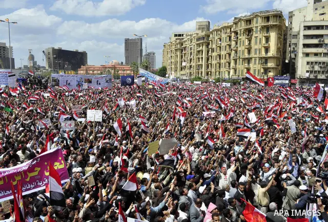 Egyptians hold flags and shout slogans as tens of thousands gathered for a demonstration at Cairo's Tahrir Square on April 8, 2011, two months after president Hosni Mubarak was ousted, to demand that former regime offici...