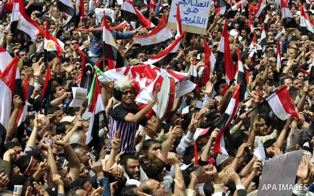 Egyptians hold flags and shout slogans as tens of thousands gathered for a demonstration at Cairo's Tahrir Square on April 8, 2011, two months after president Hosni Mubarak was ousted, to demand that former regime offici...