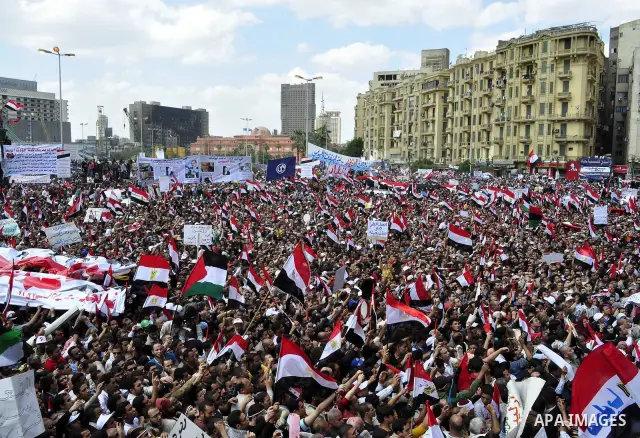Egyptians hold flags and shout slogans as tens of thousands gathered for a demonstration at Cairo's Tahrir Square on April 8, 2011, two months after president Hosni Mubarak was ousted, to demand that former regime offici...