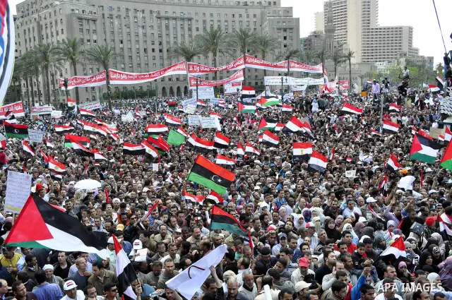 Egyptians hold flags and shout slogans as tens of thousands gathered for a demonstration at Cairo's Tahrir Square on April 8, 2011, two months after president Hosni Mubarak was ousted, to demand that former regime offici...