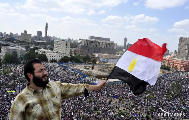 Egyptians hold flags and shout slogans as tens of thousands gathered for a demonstration at Cairo's Tahrir Square on April 8, 2011, two months after president Hosni Mubarak was ousted, to demand that former regime offici...