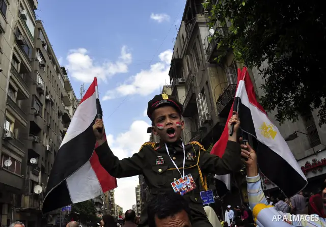Egyptians hold flags and shout slogans as tens of thousands gathered for a demonstration at Cairo's Tahrir Square on April 8, 2011, two months after president Hosni Mubarak was ousted, to demand that former regime offici...