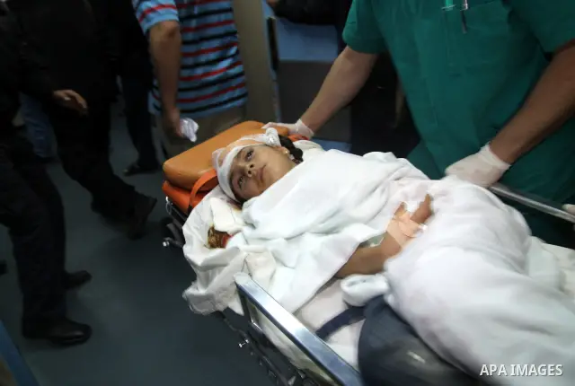 Medics wheel a wounded Palestinian girl into a hospital in Gaza City on April 8, 2011 following Israeli shelling in which two Palestinians were killed and 10 people wounded, including some children. Photo by Ali Jadallah