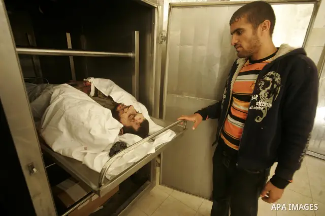 Palestinians pray over the body of the commander of the Islamic Hamas militant Tayser Abu Snima, 29, at the treatment room of Al Najar hospital following an Israeli air strikes on Hamas militants group in Rafah, southern...