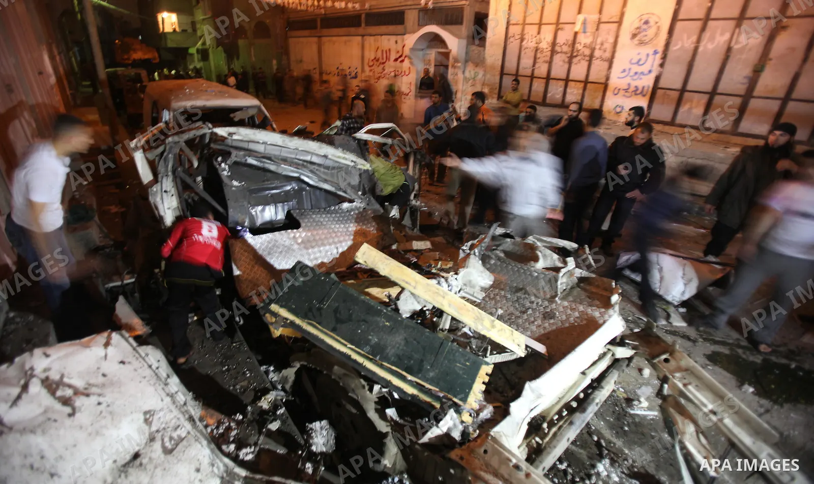 Palestinians surround a destroyed car after an Israeli airstrike in Gaza City, on April 9, 2011. Israeli aircraft and ground forces struck Gaza on Friday, killing four Hamas militants and five civilians in a surge of fig...
