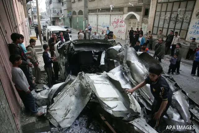 Palestinians inspect the damage to a vehicle after an Israeli air strike in Gaza City April 9, 2011. Israel killed four Palestinian militants and wounded half a dozen others as it pursued air raids in Gaza for a third da...