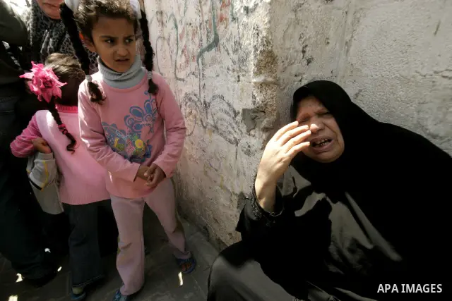A Palestinian woman mourn at the body of Hamas militant Mohammed Awaja during his funeral in Rafah in the southern Gaza Strip on April 9, 2011 as the Israeli army pounded the Gaza Strip, killing at least 12 people while...