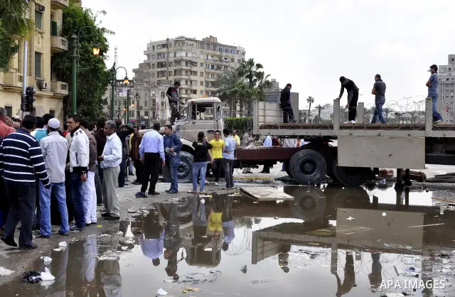 Egyptians gather past a burnt truck at Tahrir Square in Cairo on April 9, 2011 following clashes in which two people were killed and at least 18 wounded when Egyptian military police stormed the capital's iconic square t...