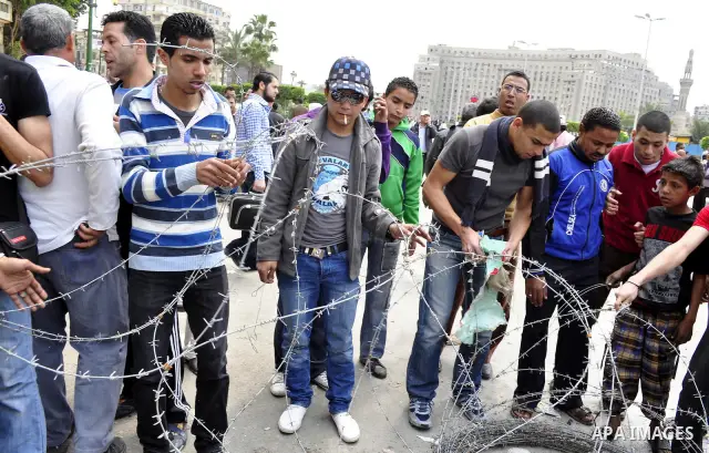Protesters chant slogans as they march following an attack by security forces in Tahrir Square, in Cairo, Egypt, Saturday, April 9, 2011. Demonstrators burned cars and barricaded themselves with barbed wire inside a cent...