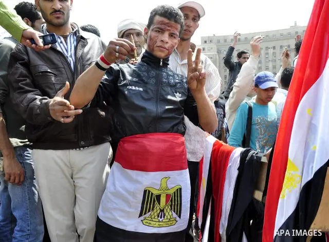 Protesters chant slogans as they march following an attack by security forces in Tahrir Square, in Cairo, Egypt, Saturday, April 9, 2011. Demonstrators burned cars and barricaded themselves with barbed wire inside a cent...