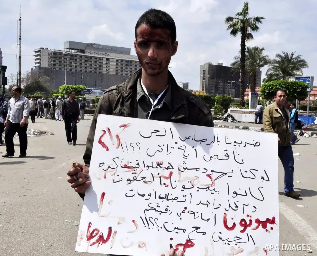 Protesters chant slogans as they march following an attack by security forces in Tahrir Square, in Cairo, Egypt, Saturday, April 9, 2011. Demonstrators burned cars and barricaded themselves with barbed wire inside a cent...