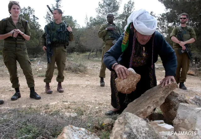 A Palestinian woman quarrels with Israeli soldiers during a protest rally against Jewish settlers in the West Bank village of Yatta, south of Hebron, on April 09,2011.Photo by Najeh Hahlamoun