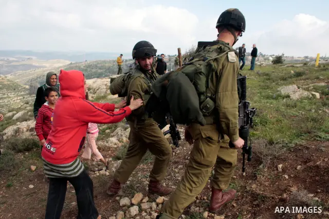 A Palestinian demonstrator argues with an Israeli soldier during a protest against Israel's controversial separation barrier organized by Palestinian and foreign peace activists in the West Bank village of Safa, near Heb...
