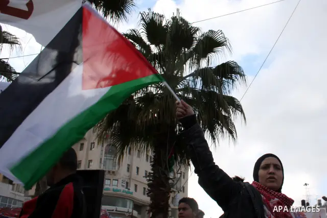 Palestinians hold national flags during a rally in solidarity with Gazans people and against the Israeli military operation, in the West Bank city of Ramallah on April 9,2011. About 18 Palestinians including 8 civilians...