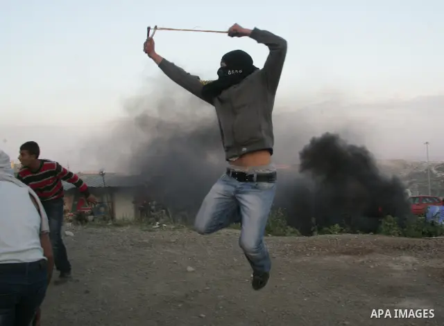 Palestinian youths hurl stones towards Israeli soldiers during clashes in the most Arab neighbourhood of Issawiah in Jerusalem on April 9,2011. Photo by Mahfouz Abu Turk