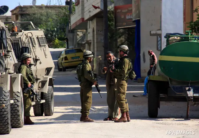 Israeli soldiers stand guard during a search operation in the village of Awarta, in the Israeli occupied northern West Bank on April 10, 2011, a day after Jewish settlers went on the rampage in two nearby Palestinian vil...