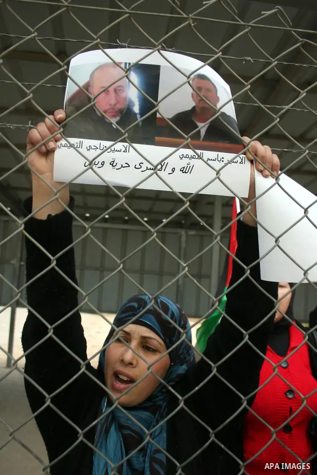 Palestinians stand at the gate of the Israeli controlled Ofer jail during a protest calling for the release of prisoners in the West Bank city of Ramallah on April 10,2011. Photo by Issam Rimawi