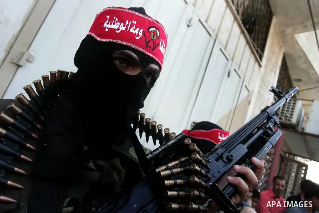 Palestinian militants of the National Resistance Brigades, the military wing of the Democratic Front for the Liberation of Palestine (DFLP), attend a news conference in the central Gaza City, 10 April 2011. Israel will c...