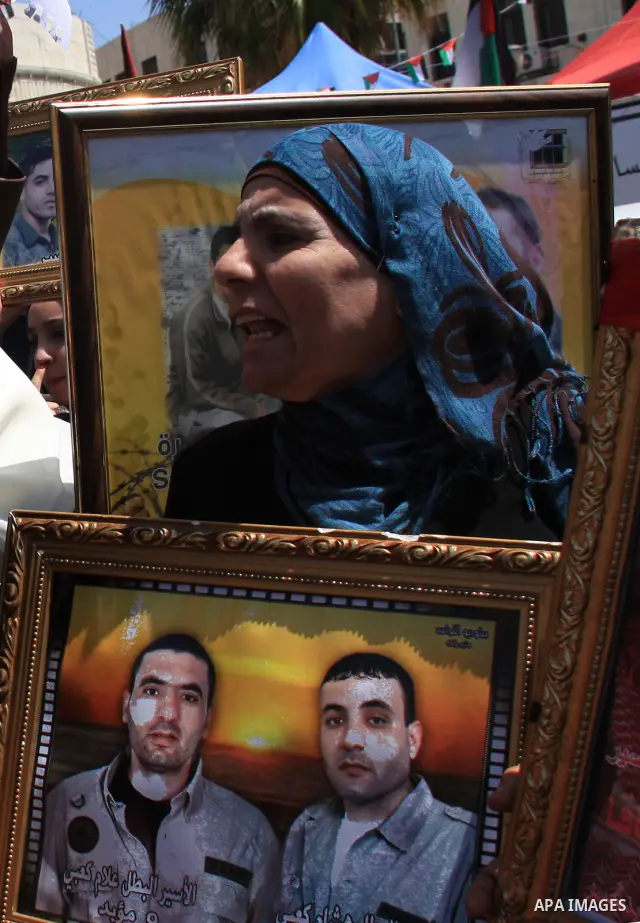 Palestinian women hold pictures of relatives during a protest calling for the release of Palestinian prisoners from Israeli jails, in the West Bank city of Nablus , Sunday, April 10, 2011. Israel currently holds about 8,...